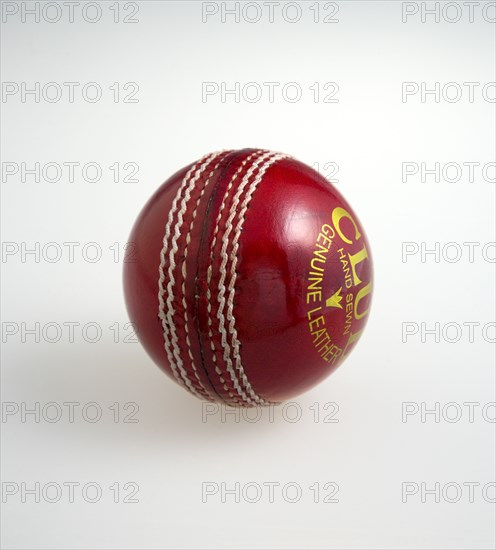 Sport, Ball Games, Cricket, Red hand stitched leather cricket ball on a white background.