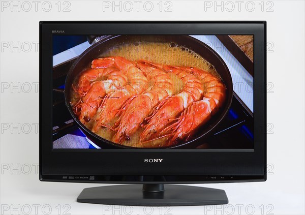Communications, Media, Television, Sony Bravia Wide Flat Screen TV on a white background showing a cookery programme with large prawns frying in a pan on a gas cooker ring.