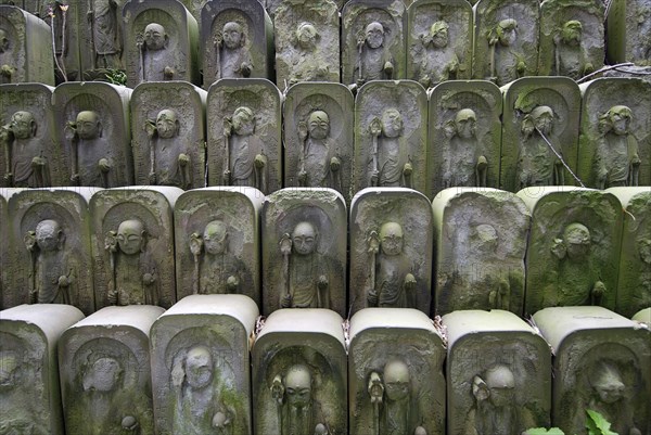 Japan, Tokyo, Nippori, dozens of stone Jizo statues of Buddha at Jomyo-in shrine.