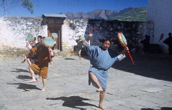 BHUTAN, Bumthang, Jakar, Dancers wearing gho traditional robes at Jakar Dzong fortress temple.