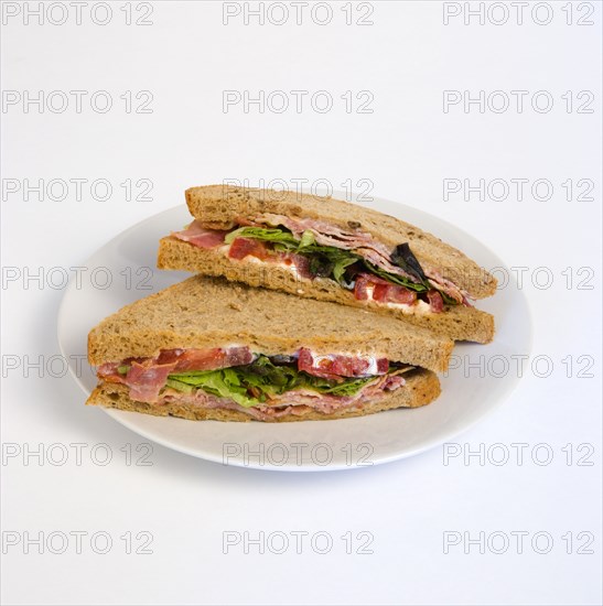 Food, Meal, Snack, Bacon lettuce and tomato BLT sandwich on a white plate against a white background.