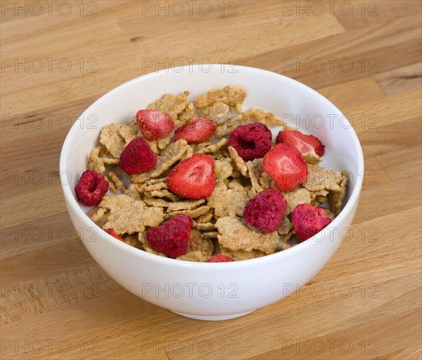 Food, Meals, Cereals, White breakfast bowl of bran flake cereal with freeze dried fruits of strawberries and raspberries in milk on a wooden table.