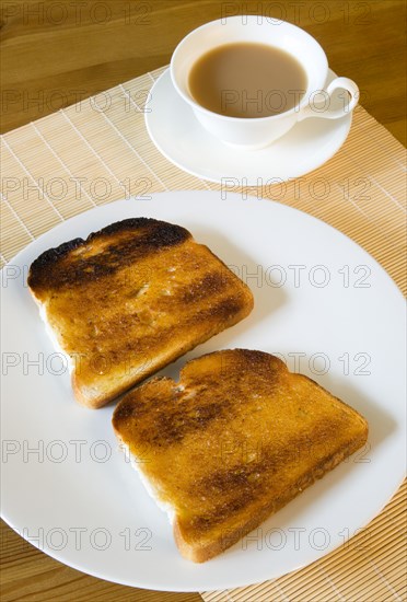 Food, Cooked, Bread, Table setting of two slices of buttered toast on a plate beside a cup of tea in a cup on a saucer.