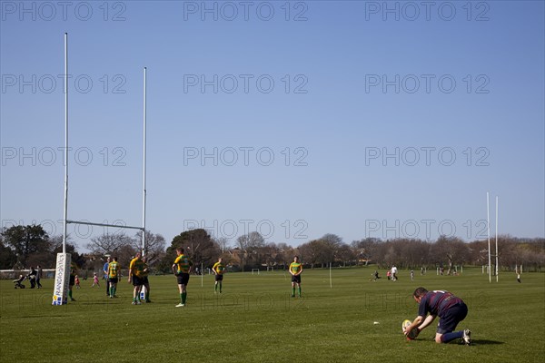 England, West Sussex, Shoreham-by-Sea, Rugby Teams playing on Victoria Park playing fields. Player placing ball to attempt to kick a conversion.