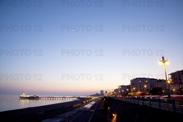 England, East Sussex, Brighton, Kemptown, view over Madeira Drive from Marine Parade with the pier illuminated at sunset. Skies clear due to no fly zone over uk because of Icelandic volcanic dust fears.