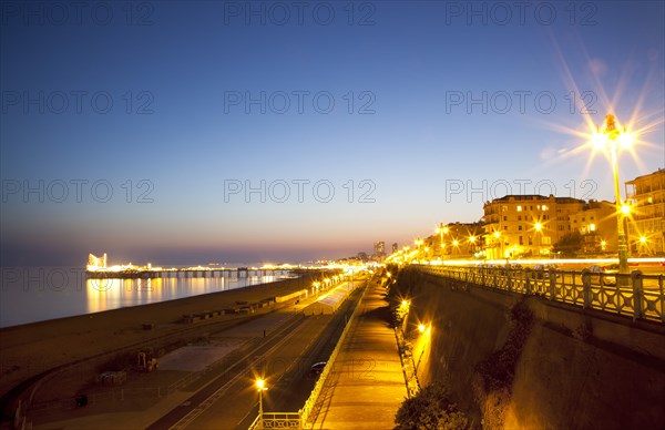 England, East Sussex, Brighton, Kemptown, view over Madeira Drive from Marine Parade with the pier illuminated at sunset. Skies clear due to no fly zone over uk because of Icelandic volcanic dust fears.