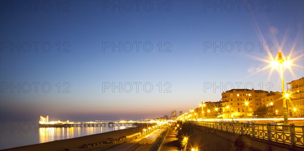 England, East Sussex, Brighton, Kemptown, view over Madeira Drive from Marine Parade with the pier illuminated at sunset. Skies clear due to no fly zone over uk because of Icelandic volcanic dust fears.