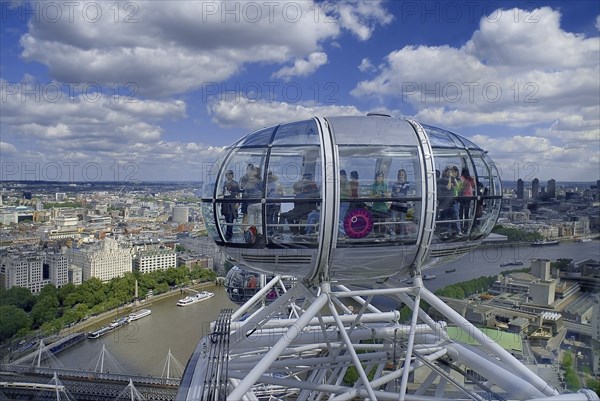 England, London, Southbank, London Eye capsule with passengers visible in capsule with the City in the background.
