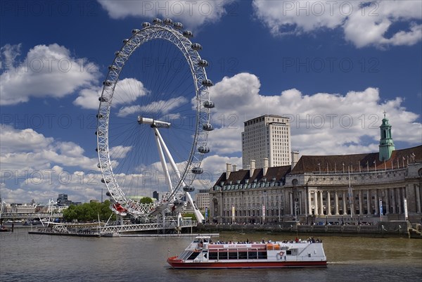 England, London, South Bank, London Eye and Aquarium from Westminster Bridge with tourist boat in foreground.