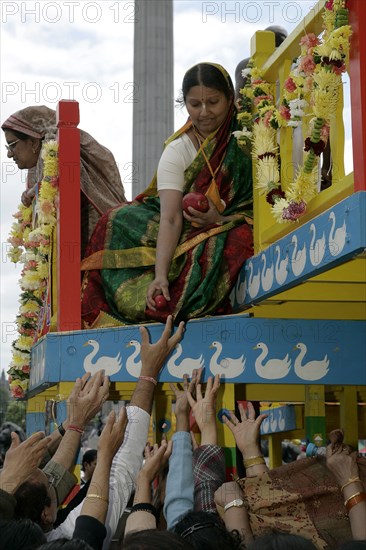 Religion, Hindu, Worship, London Rathayatra celebrations in Trafalgar Square. People handing out offerings during festival.