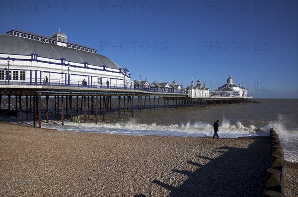 England, East Sussex, Eastbourne pier and pebble beach.