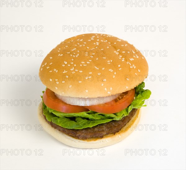 Food, Cooked, Hamburger, Single quarter pound burger with onoin tomato and lettuce in a bun on a white background.