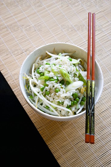 Food, Cooked, Rice, Fried rice with vegetables in a bowl with chopsticks sitting on a bamboo table mat.