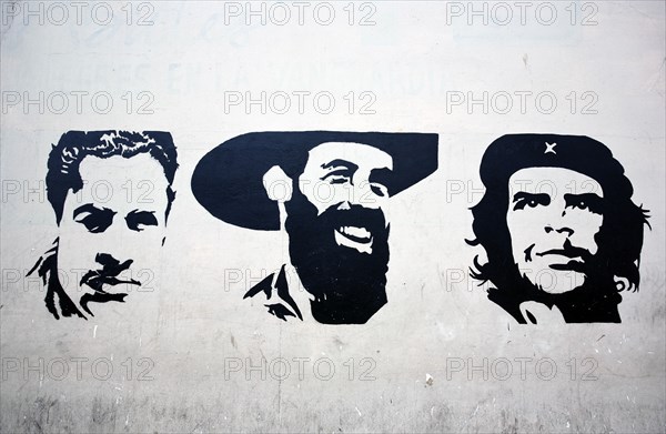 Cuba, Havana, Centro Habana, Painting of Che Guevara along with two other portraits on a wall.