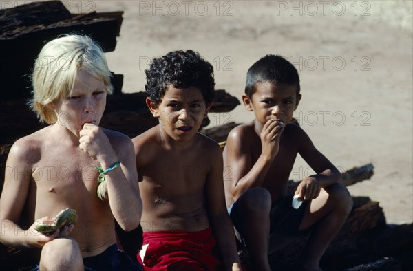 BrazilL, Para, Obidos, Children of different races eating Ingo Bau fruits.