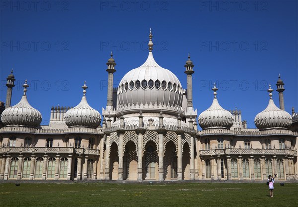 England, East Sussex, Brighton, The Royal Pavilion, 19th century retreat for the then Prince Regent, Designed by John Nash in a Indo Sarascenic style, tourist photographing herself and onion domes.