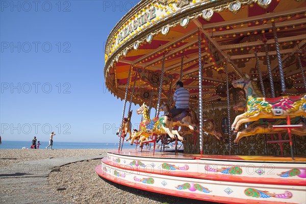 England, East Sussex, Brighton, Carousel on the pebble beach promenade.