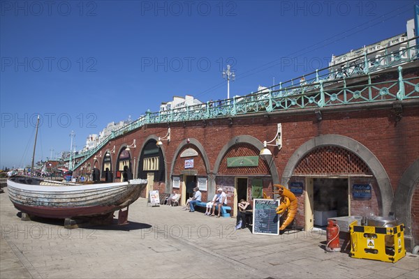England, East Sussex, Brighton, seafront arches undeer the promenade housing the fishermans club and fishing museum.
