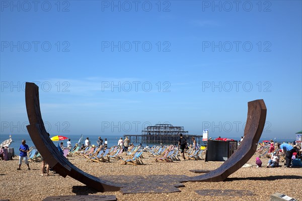 England, East Sussex, Brighton, Modern sculpture installation with the burnt out ruins of the West Pier behind.