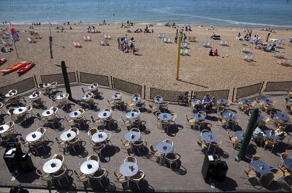 England, East Sussex, Brighton, view over tables outside seafront bar under the promenade.