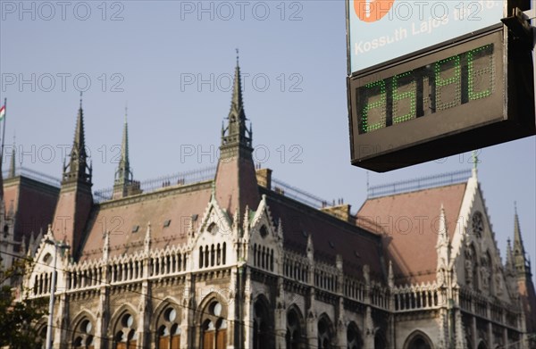 Budapest, Pest County, Hungary. Digital readout showing 25 degrees centigrade temperature with Parliament Building behind. Hungary Hungarian Europe European East Eastern Buda Pest Budapest City urban Parliament Architecture Parliament Building Sugn Temperature Digital LED Sign Destination Destinations Eastern Europe Parliment Signs Display Posted Signage