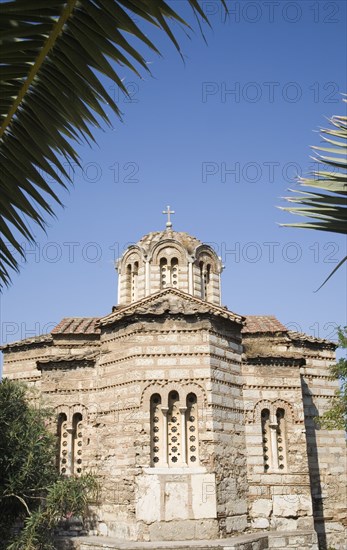 Athens, Attica, Greece. The Church of the Holy Apostles also known as Holy Apostles of Solaki located in the Ancient Agora of Athens and can be dated to around the late tenth century. Exterior facade with palm frond in foreground. Greece Greek Attica Athens Church Holy Apostles Solaki Ancient Agora Religion Religious Christian Christianity Europe European Vacation Holiday Holidays Travel Destination Tourism Ellas Hellenic Architecture Exterior Atenas Athenes Blue Destination Destinations Ellada History Historic Religion Religious Christianity Christians Southern Europe