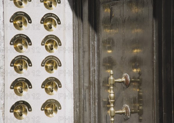 Venice, Veneto, Italy. Brass doorbells with nameplates on restored facade of apartment building entrance. Italy Italia Italian Venice Veneto Venezia Europe European City Door Entrance Bell Bells Doorbell Doorbells Handle Name Names Nameplate Destination Destinations Flat Southern Europe