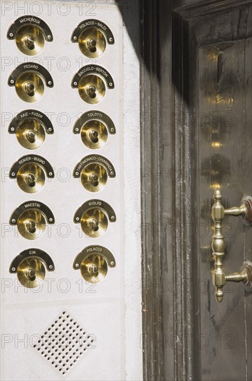 Venice, Veneto, Italy. Brass doorbells with nameplates on restored facade of apartment building entrance. Italy Italia Italian Venice Veneto Venezia Europe European City Nameplate Names Name Name Doorbells Doorbell Bells Bell Entrance Door Brass Architecture Destination Destinations Flat Southern Europe