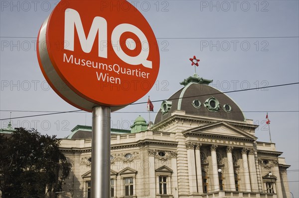 Vienna, Austria. Neubau District. Circular information sign with MQ in white on orange to indicate the Museums Quartier or Museums Quarter outside The Volkstheater. Austria Austrian Republic Vienna Viennese Wien Europe European City Capital Neubau District Sign Signs Information MQ Museums Quarter Vokstheater Architecture Building Exterior Facade Color Destination Destinations Osterreich Signs Display Posted Signage Viena Western Europe