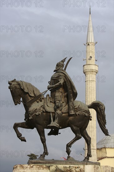 Tirana, Albania. Statue of Skanderbeg the national hero with the Ethem Bey mosque in the background. Albanian Shqip‘ria Southern Europe Albania Albanian Republic Europe European Travel Destination Indo European Tirana Tirane Architecture Statue Equestrian Figure Male Man Skanderberg Hero National Ethem Bey Mosque Muslim Moslem Islam Islamic Minaret Tower Blue Clouds Cloud Sky Destination Destinations Gray Male Men Guy Religion Religion Religious Muslims Islam Islamic