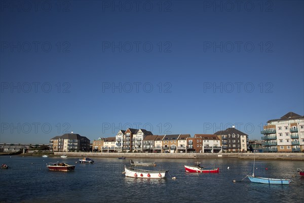 Shoreham-by-Sea, West Sussex, England. Ropetackle riverside housing developement on former industrial site. England English UK United Kingdom GB Great Britain British Europe European West Sussex County Shoreham Shoreham-by-Sea by Sea River Arun Water Waterside Modern Apartment Apartments Flat Flats Architecture Ropetackle Brown Field Development Site Boat Boats Blue Sky