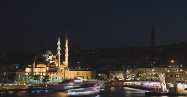 Istanbul, Turkey. Sultanahmet. The Golden Horn. The New Mosque or Yeni Camii at left the Galata Bridge and Suleymaniye Mosque at right illuminated at night with boats on the Bosphorus in motion blur. Asian Destination Destinations European Middle East Nite South Eastern Europe Turkish Turkiye Western Asia