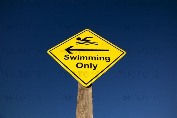 Shoreham-by-Sea, West Sussex, England. Sign indicating stretch of beach suitable for safe swimming. Sign Signs Information Warn Warning Indicate Indicating Safe Safety Yellow Blue Sky Swim Swimming Swimmer Swimmers Show Showing Point Pointing Arrow Post Only