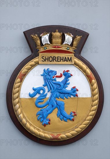 HMS Shoreham emblem on board the mine sweeper. Sign Signs Emblem Coat Arms Military Naval Royal Navy British HMS Shoreham Badge Allegory Symbol Griffin