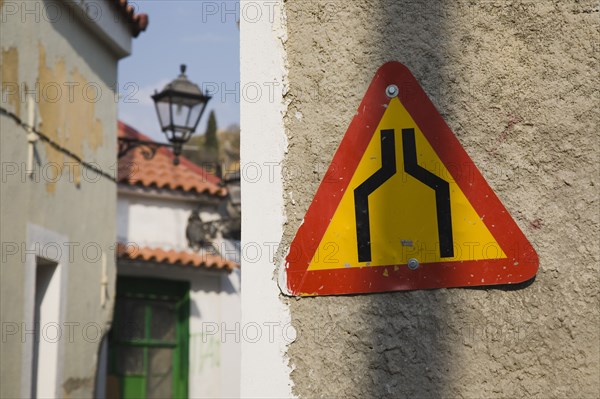 Samos Island, Northern Aegean, Greece. Vathy. Warning sign marking narrowing of street in old town. Greece Greek Europe European Vacation Holiday Holidays Travel Destination Tourism Ellas Hellenic Northern Agean Samos Island Vathy Warning Sign Road Narrows Architecture Detail Transport Communications Sign Triangular Destination Destinations Ellada Signs Display Posted Signage Southern Europe