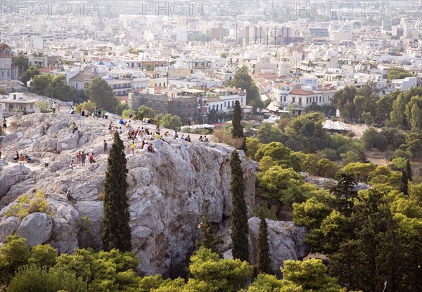 Athens, Attica, Greece. Tourists on rocks below the Acropolis overlooking Odeon of Herodes Atticus and city. Greece Greek Europe European Vacation Holiday Holidays Travel Destination Tourism Ellas Hellenic Attica Athens Acropolis Odeon Herodes Atticus City Cityscape Ruin Ruins Tourist Tourists Atenas Athenes Destination Destinations Ellada History Historic Holidaymakers Sightseeing Southern Europe