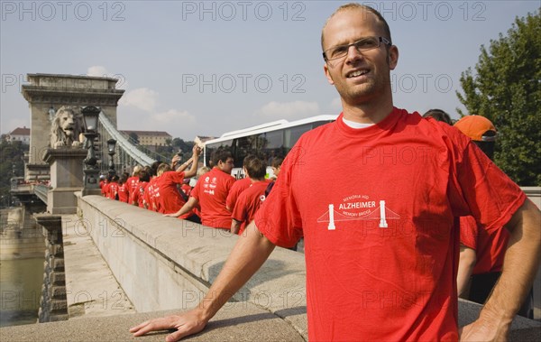 Budapest, Pest County, Hungary. Participant in charity walk in aid of Alzheimers disease sufferers at Memory Bridge also known as the Chain Bridge. Hungary Hungarian Europe European East Eastern Buda Pest Budapest City Chain Memory Bridge Alzheimers Charity Walk Walker Red T-Shirts Color Eastern Europe