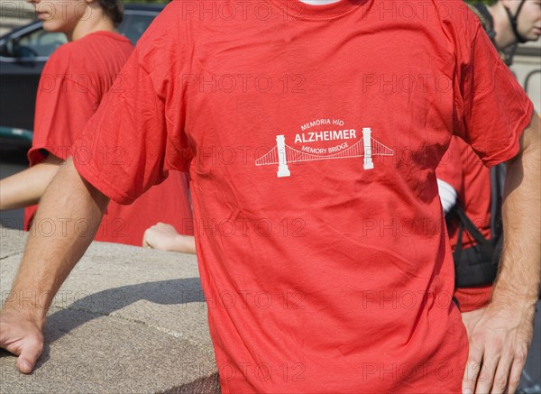 Budapest, Pest County, Hungary. Cropped view of participant in charity walk in aid of Alzheimers disease victims at Memory Bridge also known as the Chain Bridge. Hungary Hungarian Europe European East Eastern Buda Pest Budapest City T-Shirts Red Walker Walk Charity Alzheimers Bridge Memory Chain Color Eastern Europe