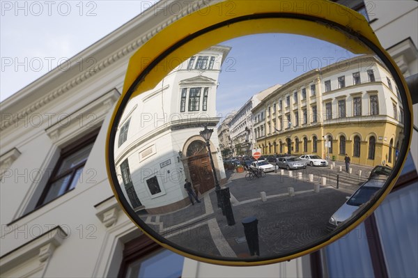 Budapest, Pest County, Hungary. Circular traffic guiding mirror reflecting apartments on River Danube bank in Pest. Hungary Hungarian Europe European East Eastern Buda Pest Budapest City Architecture Details Exterior Facade Convex Safety Mirror Reflect Refelcting Reflected Image Street View Destination Destinations Eastern Europe