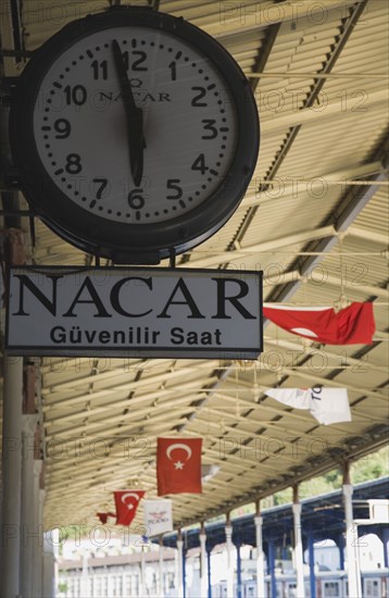 Istanbul, Turkey. Sultanahmet. Station clock giving time of three minutes to six on platform with Turkish flags hanging from roof over platform behind. Istanbul Sirkeci Terminal or Sirkeci is a terminus main station of the Turkish State Railways or TCDD in Sirkeci on the European part of Istanbul. International domestic and regional trains running westwards depart from this station which was inaugurated as the terminus of the Orient Express. Turkey Turkish Istanbul Constantinople Stamboul Stambul City Europe European Asia Asian East West Urban Destination Travel Tourism Transportt Rail Railway Train Trains Station Platform Clock Sirkeci TCCD 3 6 Destination Destinations Middle East South Eastern Europe Turkiye Western Asia