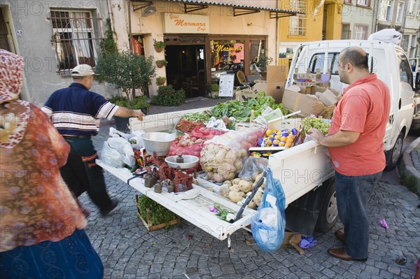 Istanbul, Turkey. Sultanahmet. Fresh fruit and vegetable produce arrives by truck for local shoppers. Set of scales on tail gate with sacks of potatoes and boxes of oranges in the back. Turkey Turkish Istanbul Constantinople Stamboul Stambul City Europe European Asia Asian East West Urban Destination Sultanahmet Market Markets Stall Vegetable Vegetables Food Produce Vendor Selling Truck Van Scales Destination Destinations Lorry Middle East South Eastern Europe Turkiye Western Asia