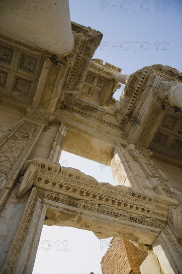 Selcuk, Izmir Province, Turkey. Ephesus. Roman Library of Celsus facade. Angled view looking up at decoratively carved roof and doorway. Turkey Turkish Eurasia Eurasian Europe Asia Turkiye Izmir Province Selcuk Ephesus Ruin Ruins Roman Library Celcus Column Columns Facde Ancient Architecture Masonry Rock Stone Destination Destinations European History Historic Middle East South Eastern Europe Western Asia