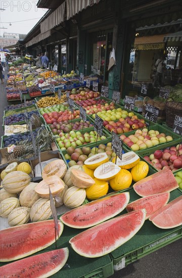 Vienna, Austria. The Naschmarkt. Display of fresh fruit for sale on stall outside shopfront including apples melon and pineapple. Austria Austrian Republic Vienna Viennese Wien Europe European City Capital Naschmarkt Market Display Fresh Food Fruit Vegetables Veg Vegetable Stall Shop Store Destination Destinations Osterreich Viena Western Europe