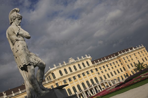 Vienna, Austria. Roman statue in the gardens of the Schonbrunn Palace Austria Austrian Vienna Wien Viennese Republic Austro-Bavarian Wean Europe European City Capital Exterior Travel Destination SchonnBrunn Schonbrunn Schloss Palace Architecture Art Imperial Summer Residence UNESCO World Heritage Site Beautifu Spring Blue Clouds Cloud Sky Destination Destinations Garden Plants Flora Gray History Historic Osterreich Viena Western Europe