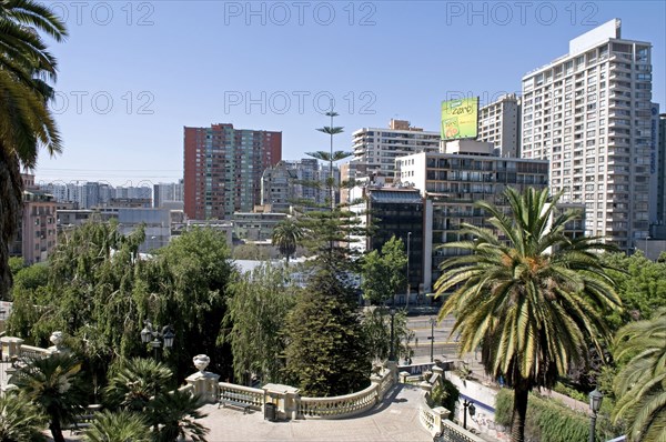 Santiago, Chile. Highrise modern apartment blocks in downtown from the Cerro Santa Lucia with sweeping classical balustrade and Chilean Palm tree in the foreground. Chile Chilean South America American Hispanic Santiago City Cityscape Urban Highrise Apartment Apartments Block Blocks Towers Flats Cerro Santa Lucia Palm Tree Trees Caribbean Destination Destinations Flat Latin America Latino South America Southern Windward Islands