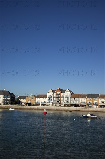 Shoreham-by-Sea, West Sussex, England. Ropetackle riverside housing developement on former industrial site. England English UK United Kingdom GB Great Britain British Europe European West Sussex County Shoreham Shoreham-by-Sea by Sea River Arun Water Waterside Modern Apartment Apartments Flat Flats Architecture Ropetackle Brown Field Development Site Boat Boats Blue Sky