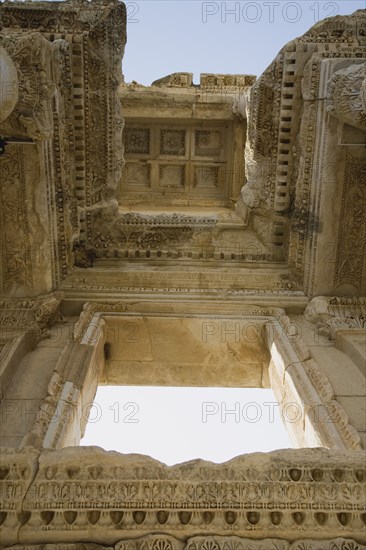 Selcuk, Izmir Province, Turkey. Ephesus. Roman Library of Celsus. View from below looking up at highly carved ceiling and window surround. Turkey Turkish Eurasia Eurasian Europe Asia Turkiye Izmir Province Selcuk Ephesus Ruin Ruins Roman Library Celcus Column Columns Facde Ancient Architecture Masonry Rock Stone Destination Destinations European History Historic Middle East South Eastern Europe Western Asia