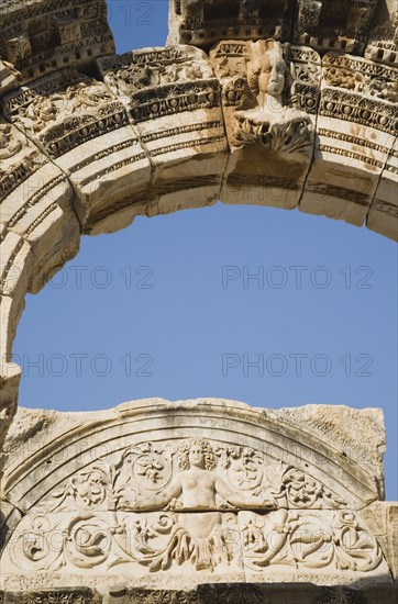 Selcuk, Izmir Province, Turkey. Ephesus. Detail of carved stone and arch in antique city of Ephesus on the Aegean sea coast. Turkey Turkish Eurasia Eurasian Europe Asia Turkiye Izmir Province Selcuk Ephesus Ruin Ruins Roman Column Columns Facde Ancient Architecture Masonry Rock Stone Arch Blue Destination Destinations European History Historic Middle East South Eastern Europe Water Western Asia