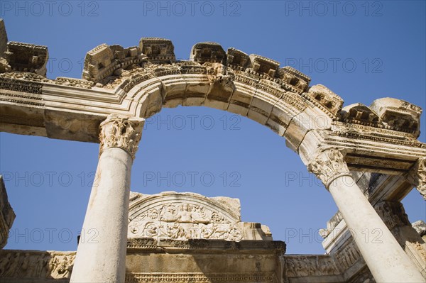 Selcuk, Izmir Province, Turkey. Ephesus. Carved archway supporting columns and wall frieze in antique city of Ephesus on the Aegean sea coast. Turkey Turkish Eurasia Eurasian Europe Asia Turkiye Izmir Province Selcuk Ephesus Ruin Ruins Roman Column Columns Facde Ancient Architecture Masonry Rock Stone Arch Blue Destination Destinations European History Historic Middle East South Eastern Europe Water Western Asia