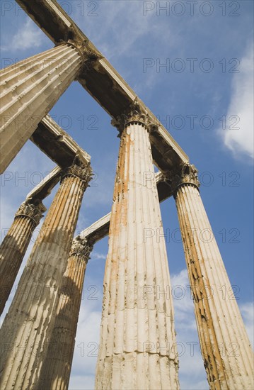 Athens, Attica, Greece. The Temple of Olympian Zeus corinthian capitals and architraves of ruined temple dedicated to king of the Olympian gods Zeus. Greece Greek Attica Athens Europe European Vacation Holiday Holidays Travel Destination Tourism Ellas Hellenic Acropolis Parthenon Temple Olympian Zeus Ruin Ruins Column Columns Atenas Athenes Blue Clouds Cloud Sky Destination Destinations Ellada History Historic Southern Europe